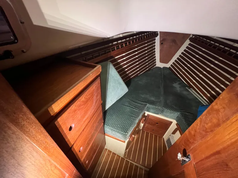 Slide: The Image of 1987 Bayfield 32C sailboat cabin with wood paneling and cozy sleeping area. - 31