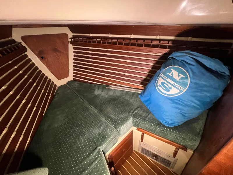 Slide: The Image of Cozy cabin interior of 1987 Bayfield 32C sailboat with green cushions and blue bag. - 33