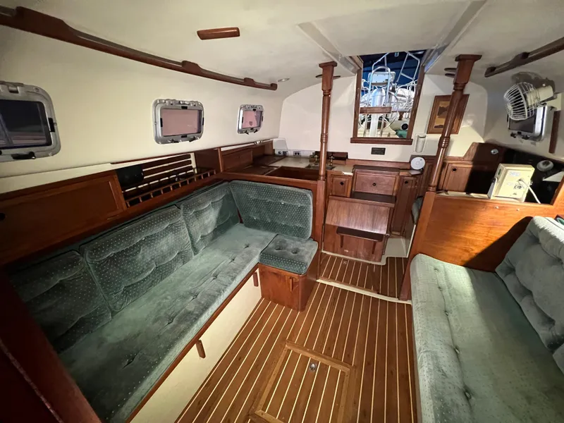 Slide: The Image of Interior of 1987 Bayfield 32C sailboat with wooden furnishings and green upholstery. - 35