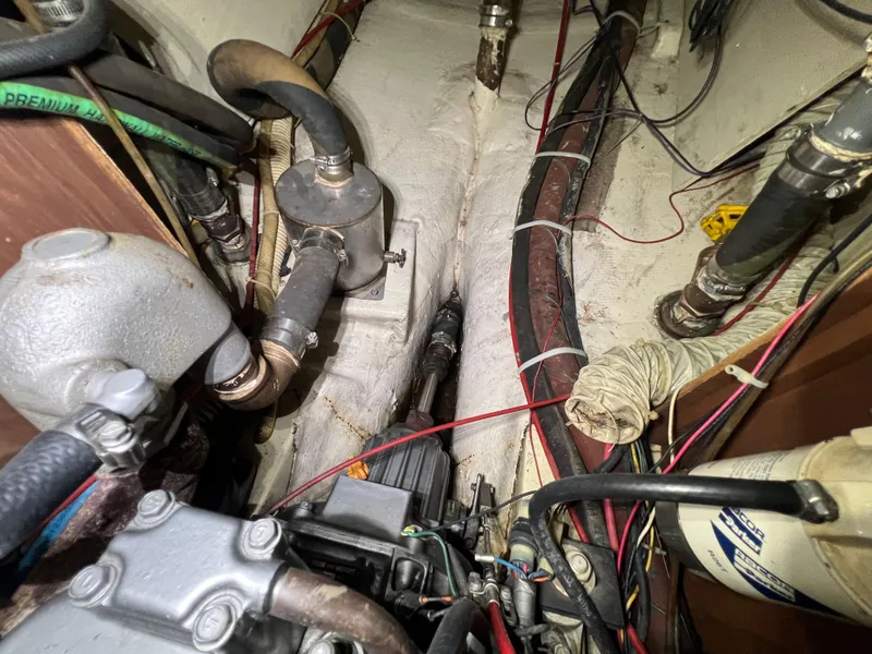 Slide: The Image of Engine compartment of a 1987 Bayfield 32C sailboat with visible hoses and wiring. - 39