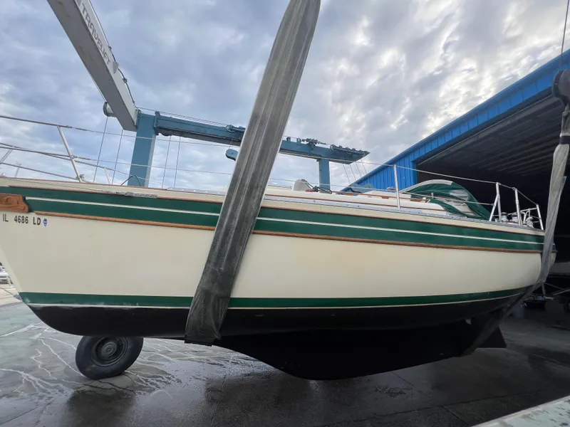 Slide: The Image of 1987 Bayfield 32C sailboat in dry dock, featuring green and white hull. - 42