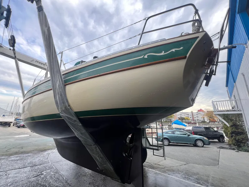 Slide: The Image of 1987 Bayfield 32C sailboat in dry dock, green and cream hull, overcast sky. - 43
