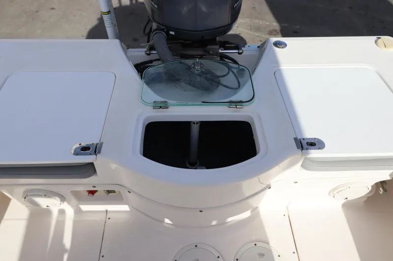 Slide: The Image of 2012 Everglades 243 Center Console boat interior with storage compartments and motor. - 15