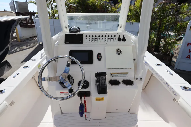 Slide: The Image of 2012 Everglades 243 Center Console boat dashboard with steering wheel and controls. - 23