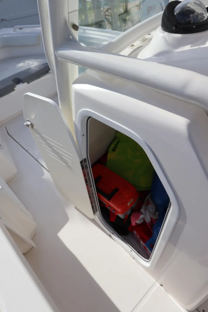 Slide: The Image of Storage compartment on 2012 Everglades 243 Center Console boat, open with gear inside. - 32
