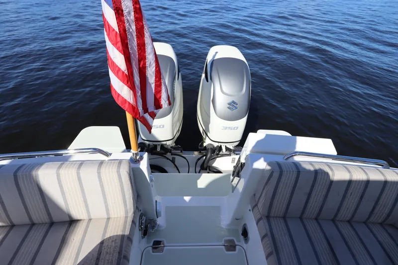 Slide: The Image of Back Cove 34O 2019 boat with twin Suzuki 350 engines and American flag on calm water. - 14
