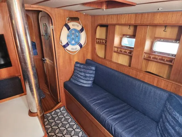 Slide: The Image of Interior of 1982 Custom King's Legend 41 yacht with blue sofa and wooden paneling. - 23