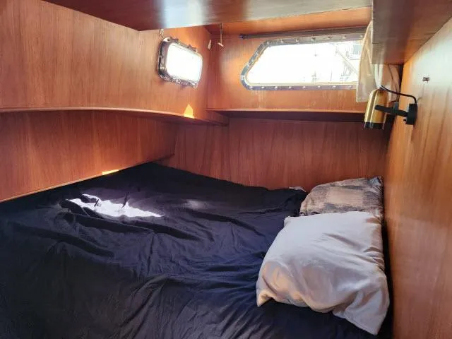Slide: The Image of Cozy cabin interior of 1982 Custom King's Legend 41 sailboat with wooden paneling and bedding. - 26
