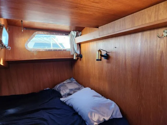 Slide: The Image of Cozy cabin interior of 1982 Custom King's Legend 41 sailboat with wooden paneling and bedding. - 27