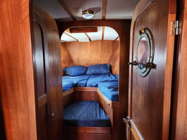 Slide: The Image of Cozy cabin interior of 1982 King's Legend 41 sailboat with wooden finish and blue bedding. - 30