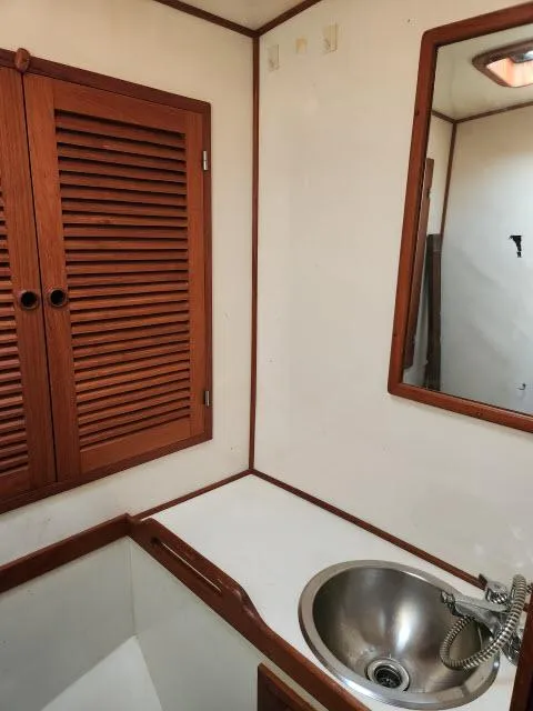 Slide: The Image of 1982 Custom King's Legend 41 yacht bathroom with wooden cabinets and stainless steel sink. - 34