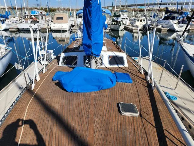 Slide: The Image of 1982 Custom King's Legend 41 sailboat docked in marina, wooden deck, blue covers. - 41