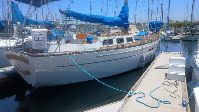 Slide: The Image of 1982 Custom King's Legend 41 sailboat docked in marina, blue covers, sunny day. - 43