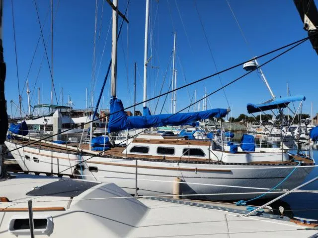 Slide: The Image of 1982 Custom King's Legend 41 sailboat docked in a marina under clear blue skies. - 47
