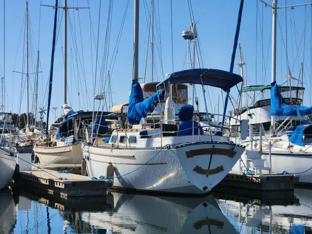 Slide: The Image of 1982 Custom King's Legend 41 sailboat docked in a marina, surrounded by other boats. - 48