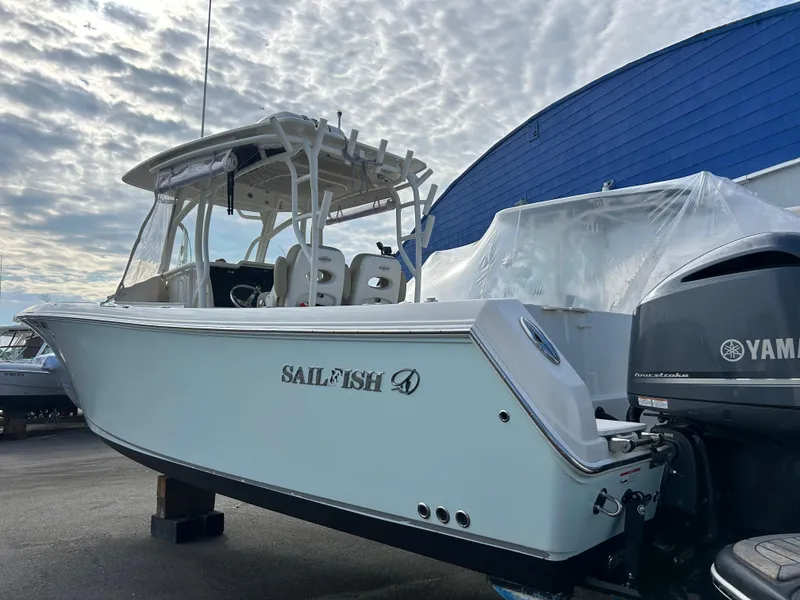 Slide: The Image of 2018 Sailfish 290 CC boat with Yamaha engine, docked under cloudy sky. - 1