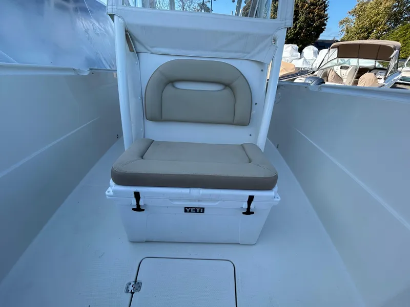 Slide: The Image of 2018 Sailfish 290 CC boat interior with cushioned seating and Yeti cooler. - 5