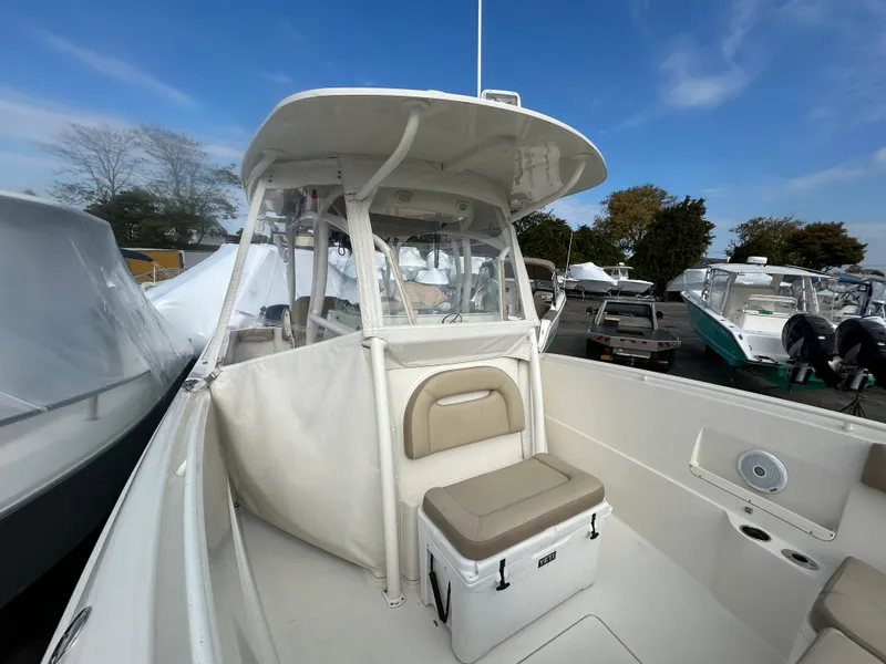 Slide: The Image of 2018 Sailfish 290 CC boat with seating and storage, docked outdoors under clear sky. - 6