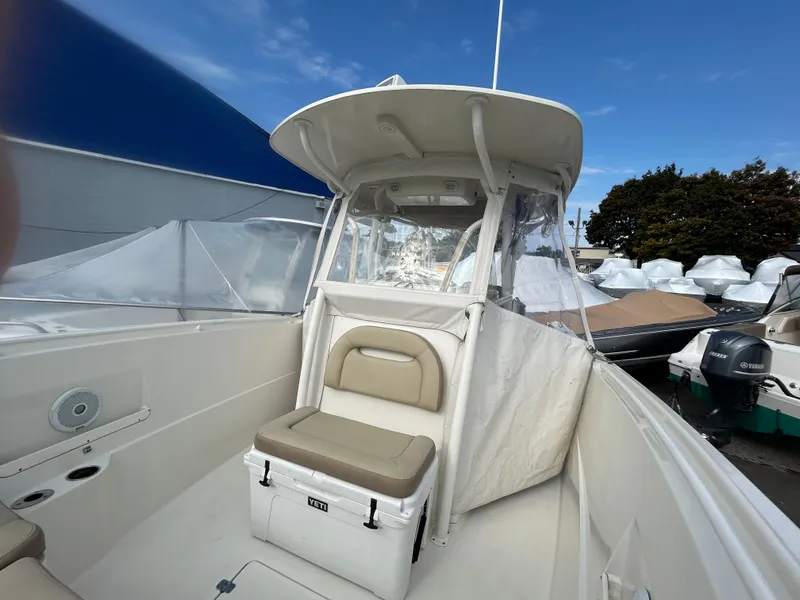 Slide: The Image of 2018 Sailfish 290 CC boat with seating and canopy, docked under clear blue sky. - 8