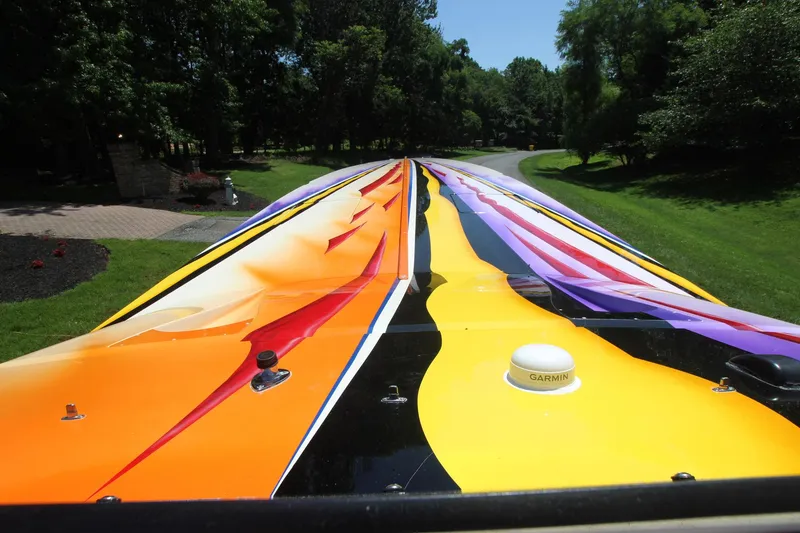 Slide: The Image of Colorful deck of 2001 Cigarette 46 Rough Rider boat, vibrant design in a lush setting. - 12