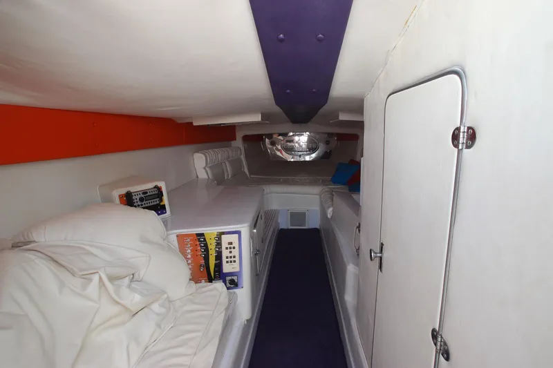 Slide: The Image of Interior cabin of 2001 Cigarette 46 Rough Rider boat, featuring white and purple accents. - 14