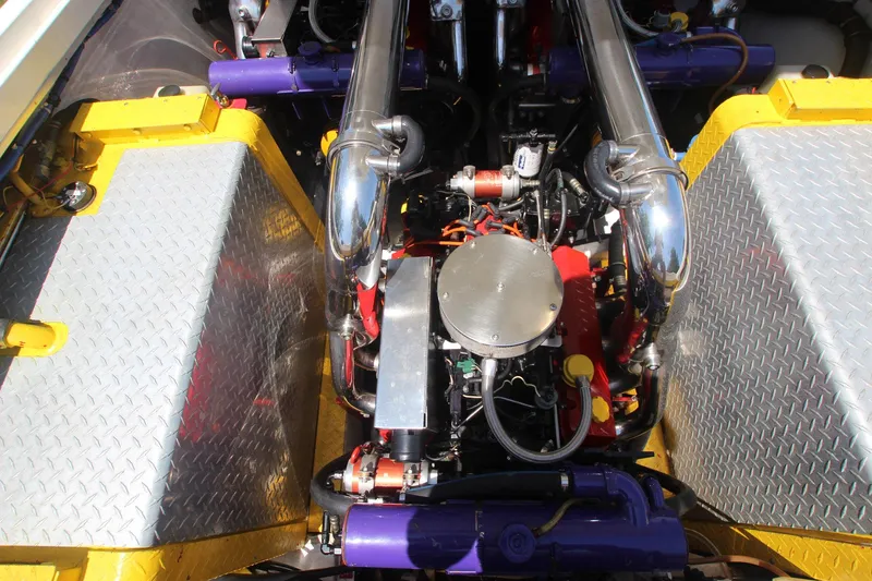 Slide: The Image of Engine compartment of a 2001 Cigarette 46 Rough Rider boat, featuring chrome and colorful components. - 27