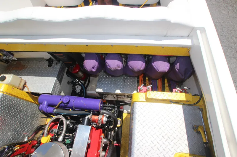 Slide: The Image of Engine compartment of 2001 Cigarette 46 Rough Rider boat with purple accents and diamond plate flooring. - 28