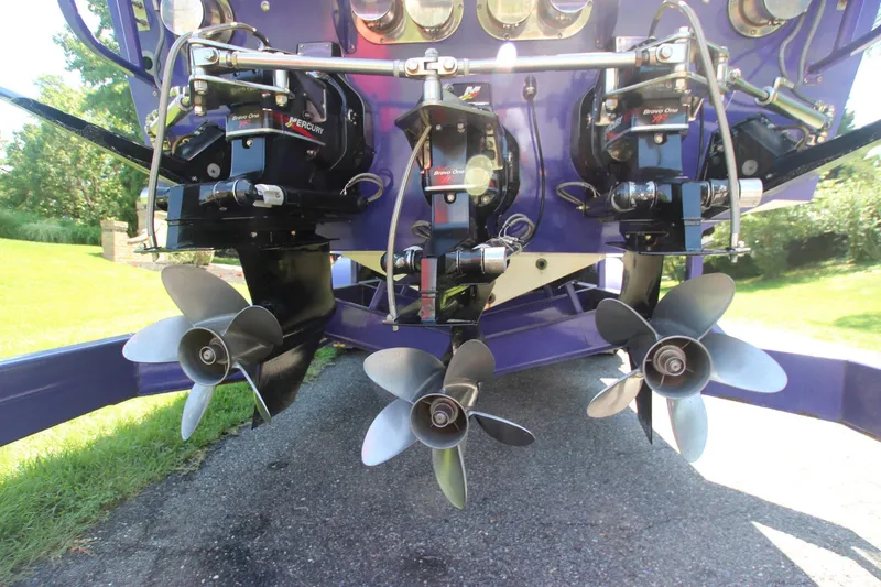 Slide: The Image of Triple propellers of a 2001 Cigarette 46 Rough Rider boat, displayed outdoors. - 32