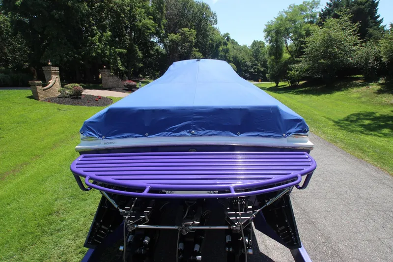 Slide: The Image of Covered 2001 Cigarette 46 Rough Rider boat on a driveway, surrounded by greenery. - 33