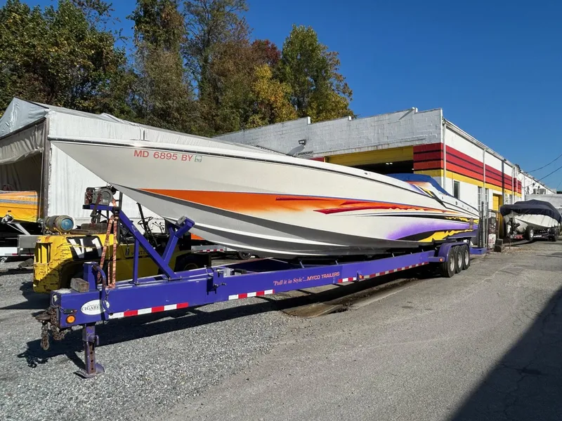 Slide: The Image of 2001 Cigarette 46 Rough Rider boat on trailer, parked outdoors near a building. - 35