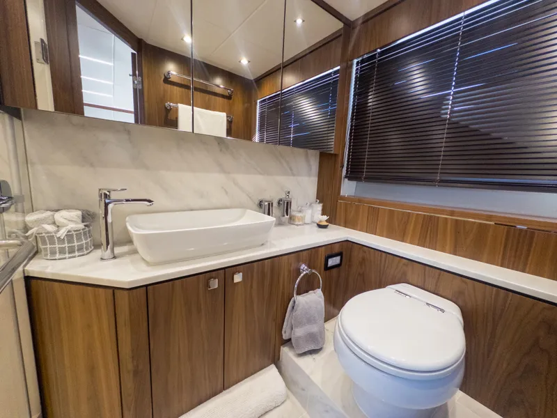 Slide: The Image of Luxurious bathroom in 2020 Sunseeker Predator 74 yacht with modern fixtures and wood accents. - 24