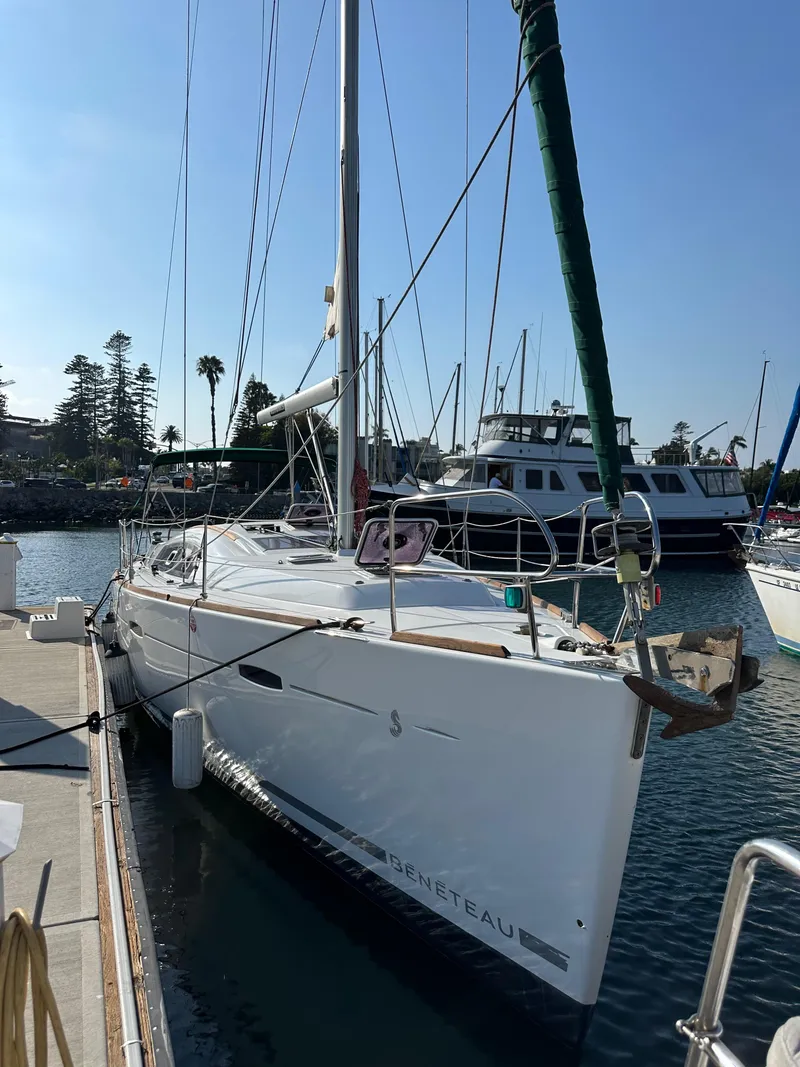 Slide: The Image of 2011 Beneteau Oceanis 40 sailboat docked in a marina under clear blue skies. - 2
