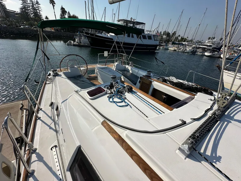 Slide: The Image of 2011 Beneteau Oceanis 40 sailboat docked in marina, showcasing deck and steering wheel. - 23