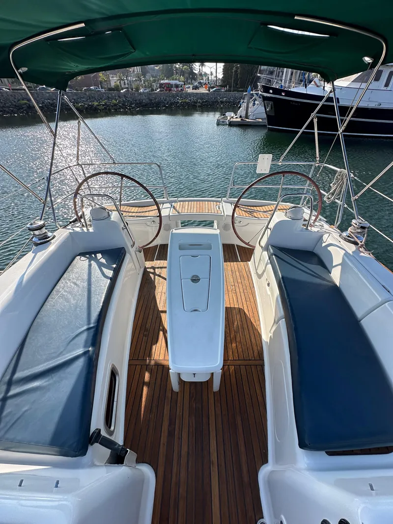 Slide: The Image of 2011 Beneteau Oceanis 40 sailboat cockpit with dual steering wheels and teak flooring. - 25