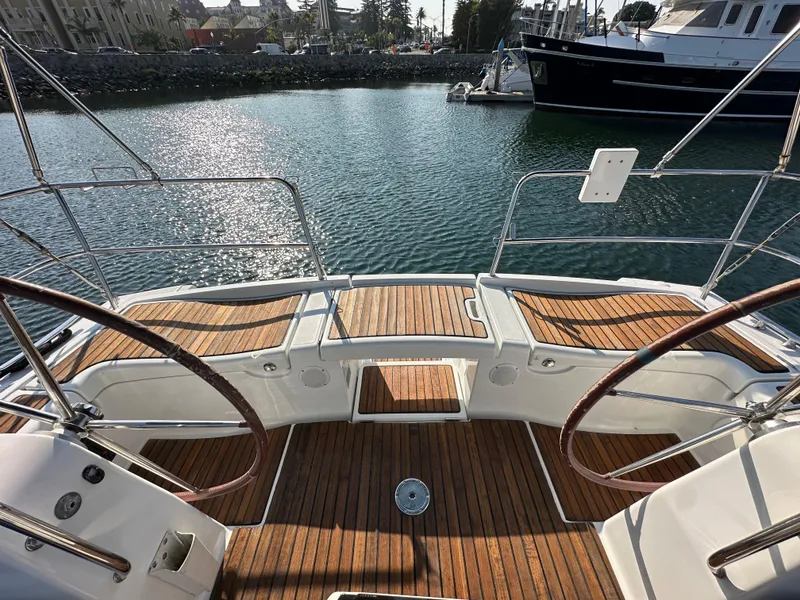 Slide: The Image of Beneteau Oceanis 40 sailboat cockpit with dual steering wheels, teak decking, docked in marina. - 27