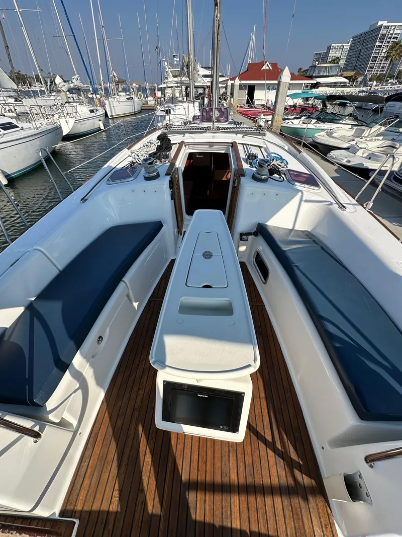Slide: The Image of 2011 Beneteau Oceanis 40 sailboat with spacious deck and seating, docked in a marina. - 42