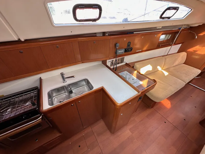 Slide: The Image of Interior of 2011 Beneteau Oceanis 40 yacht, featuring kitchen and seating area. - 48