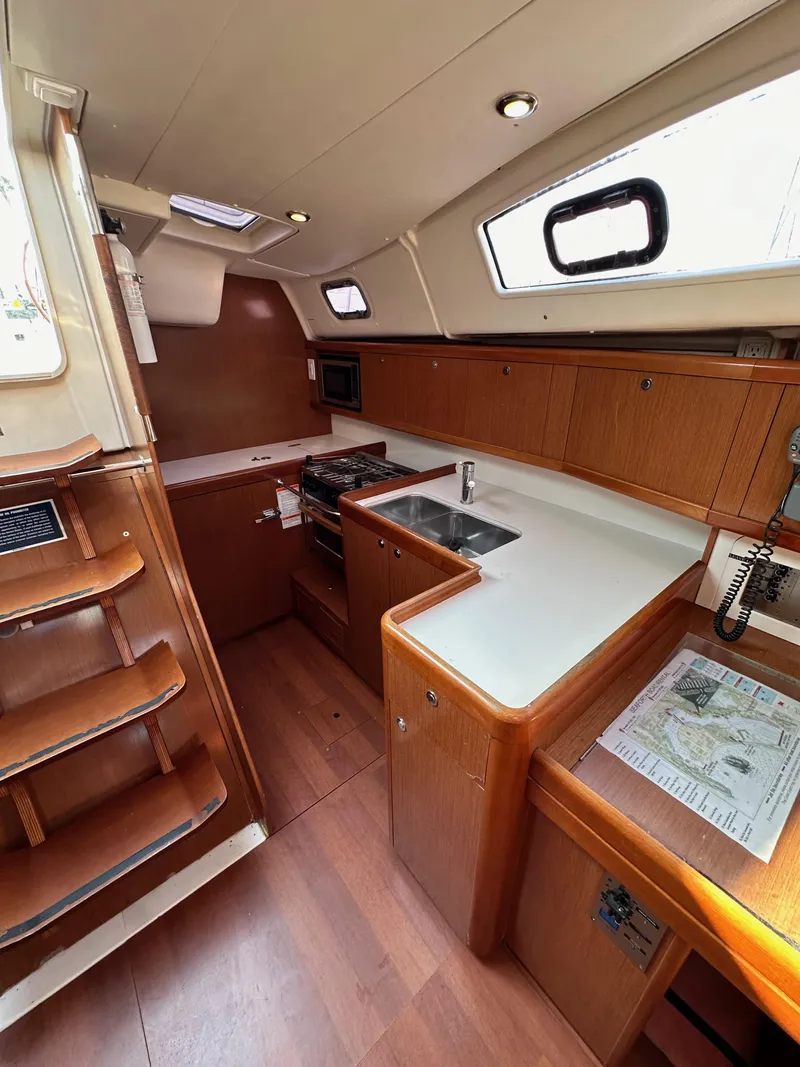 Slide: The Image of Interior of 2011 Beneteau Oceanis 40 sailboat with modern kitchen and wooden cabinetry. - 49
