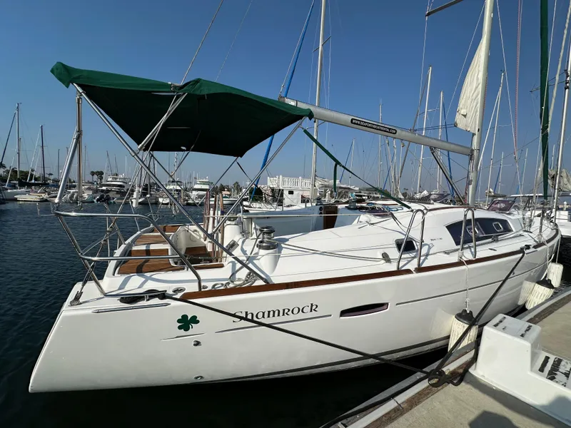 Slide: The Image of 2011 Beneteau Oceanis 40 sailboat docked in marina, green canopy, named "Shamrock." - 9