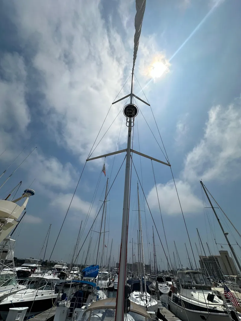 Slide: The Image of Jeanneau Sun Odyssey 410 sailboat mast against a bright sky in a marina, 2020 model. - 33