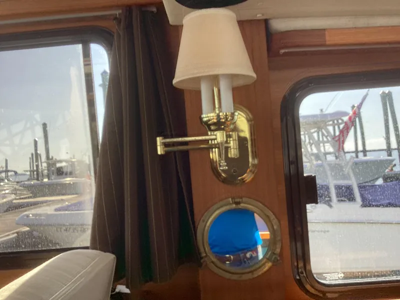 Slide: The Image of Interior of 2012 Ranger Tugs R-27 with brass lamp and porthole window. - 12