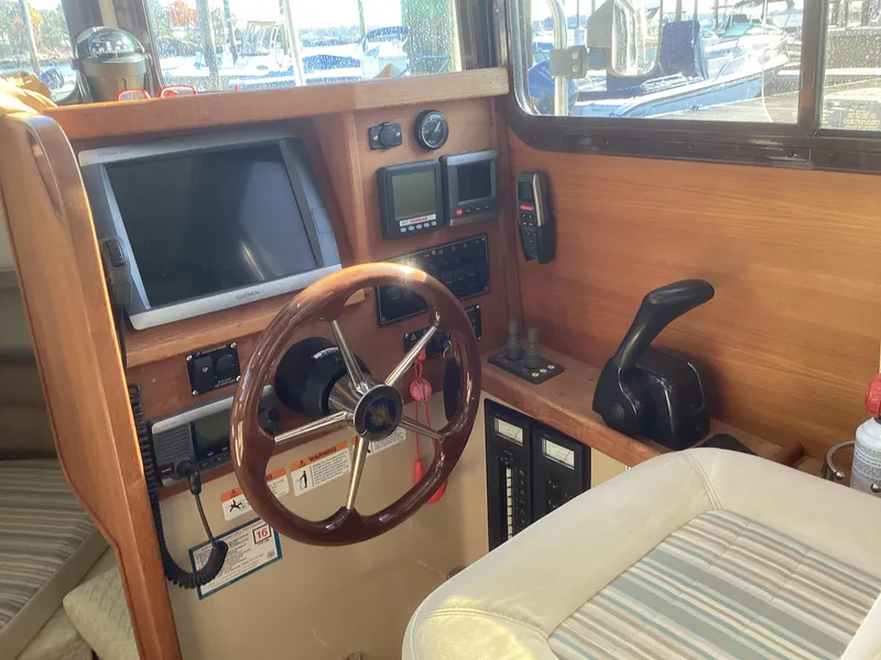 Slide: The Image of Interior helm of 2012 Ranger Tugs R-27 with steering wheel and navigation equipment. - 13