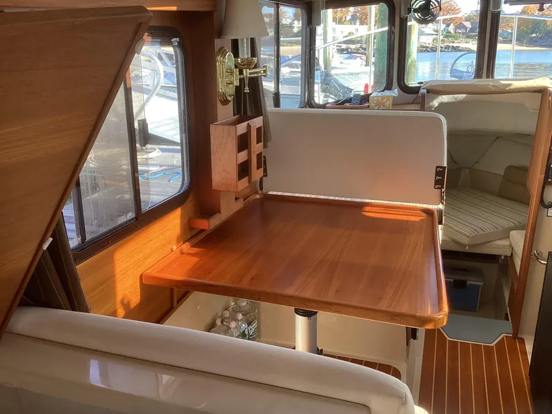 Slide: The Image of Interior of 2012 Ranger Tugs R-27 with wooden table and seating area. - 14