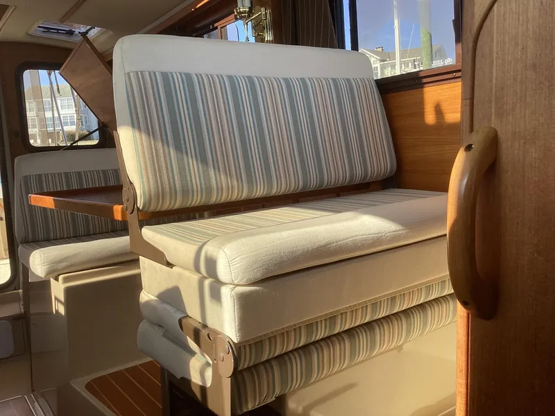 Slide: The Image of Interior of 2012 Ranger Tugs R-27 with striped seating and wooden accents. - 22