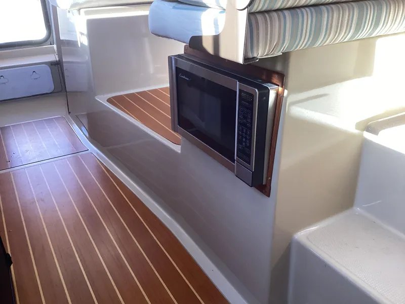 Slide: The Image of Interior of 2012 Ranger Tugs R-27 with wood flooring and built-in microwave. - 23
