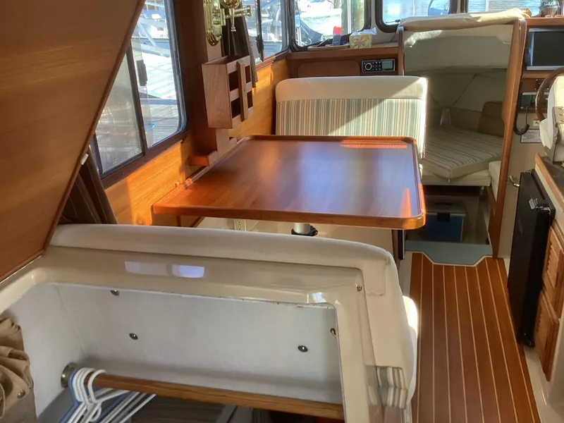 Slide: The Image of Interior of 2012 Ranger Tugs R-27 boat with wooden table and seating area. - 25