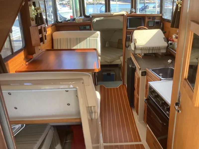 Slide: The Image of Interior of 2012 Ranger Tugs R-27 boat with wood finishes and compact kitchen. - 26