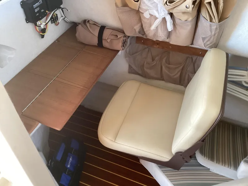 Slide: The Image of 2012 Ranger Tugs R-27 interior with beige seat, wooden table, and storage pouches. - 28