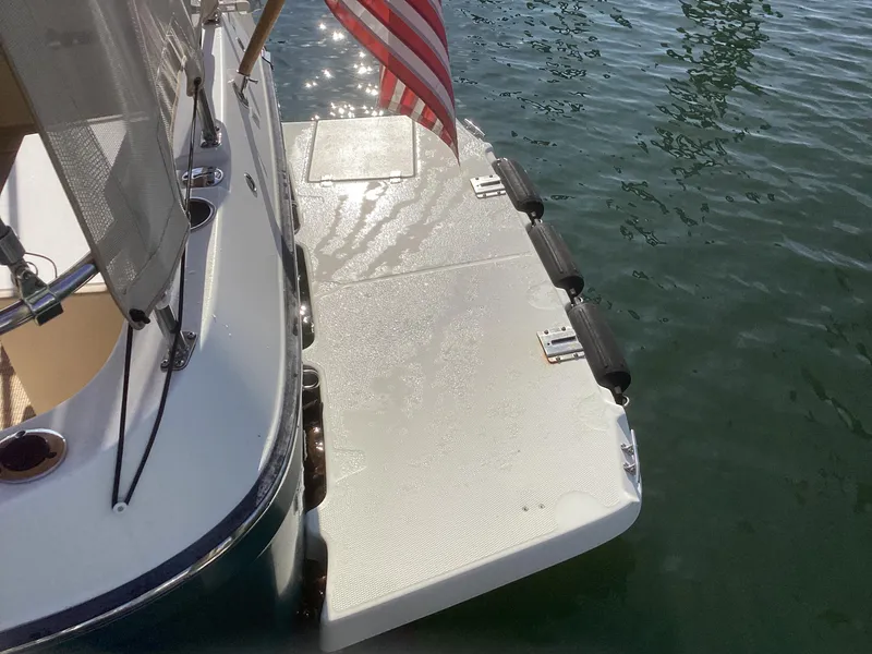 Slide: The Image of 2012 Ranger Tugs R-27 boat with swim platform and American flag on calm water. - 39