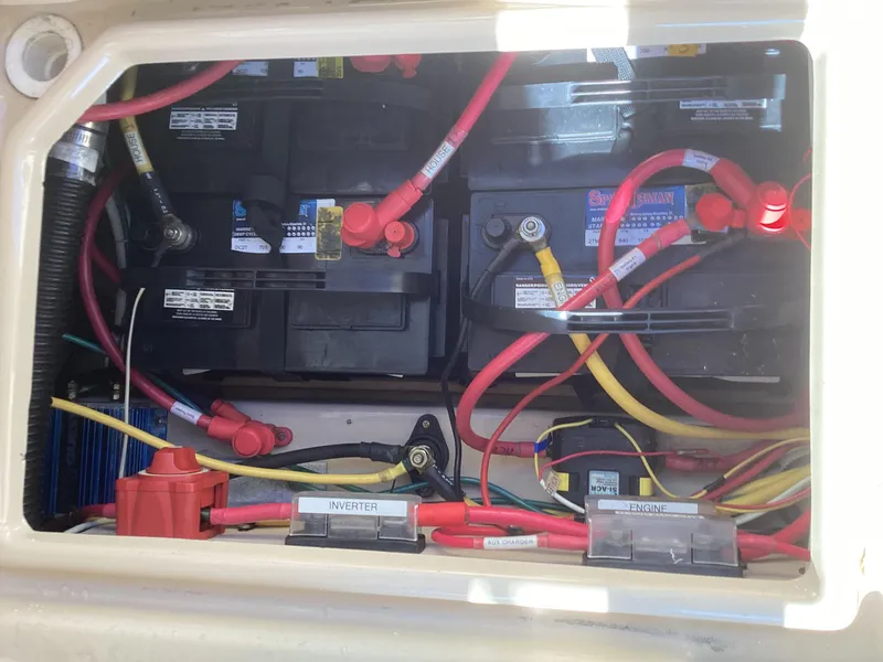 Slide: The Image of 2012 Ranger Tugs R-27 battery compartment with wiring and inverter labels. - 41